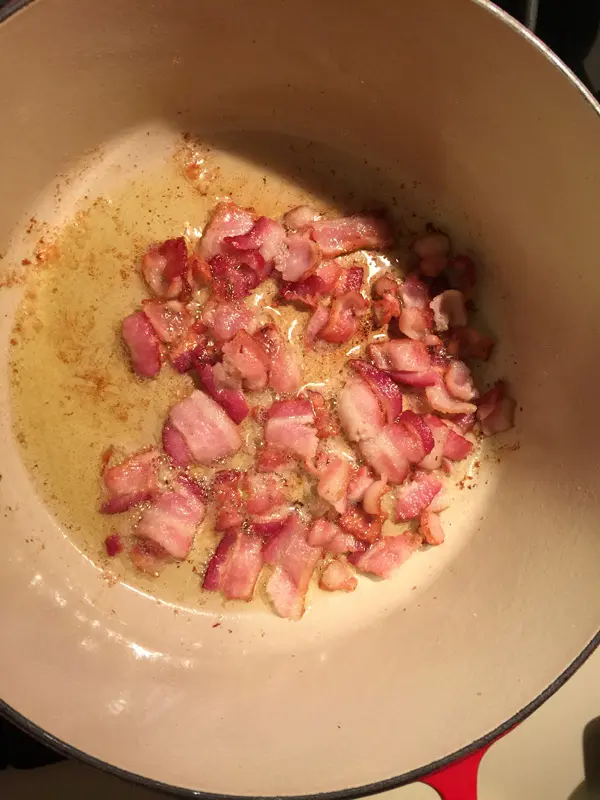 Bacon sizzling in the bottom of a pan