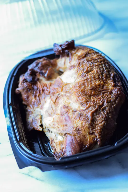 A rotisserie turkey breast in a container
