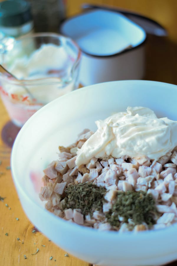 Herbs and mayonnaise in the bowl with the turkey breast