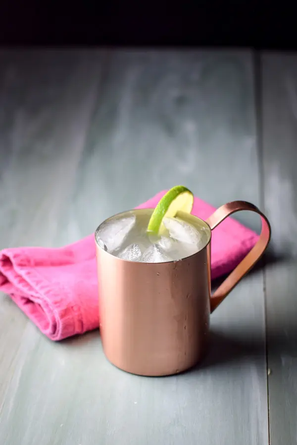 A copper mug filled with the mule with a lime on the rim