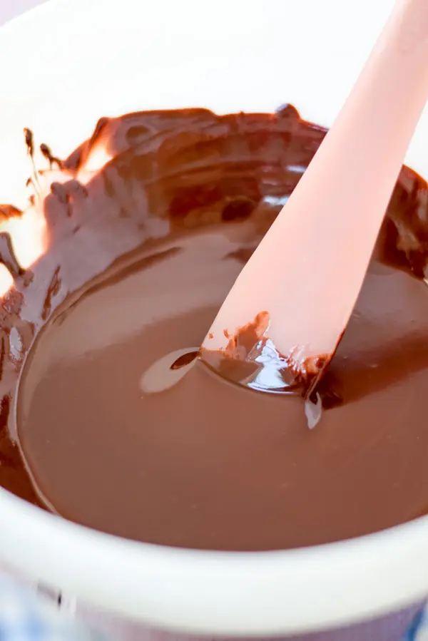 Melted chocolate in a white bowl and a pink spatula in it
