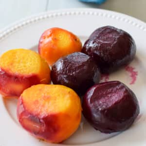 A white beaded plate with three red and three yellow beets - square
