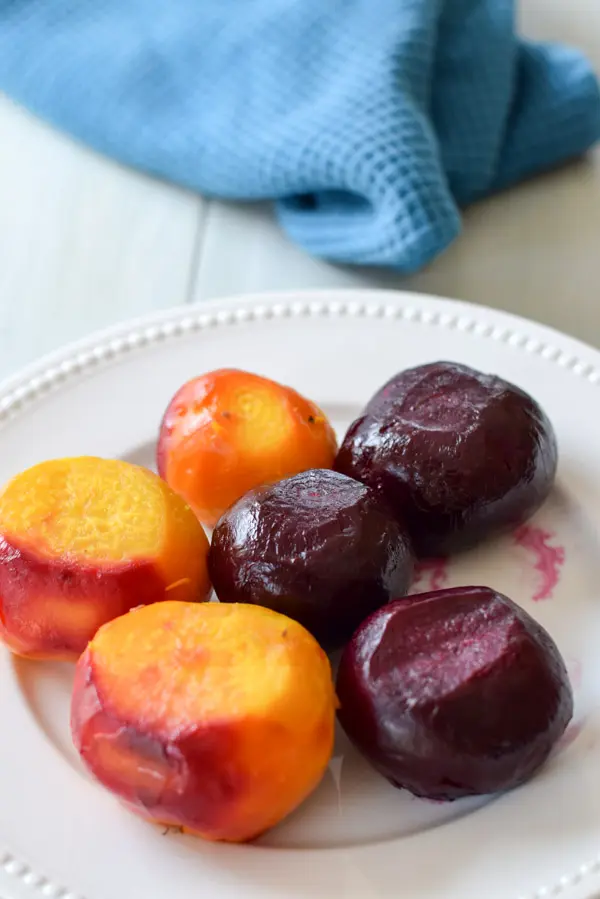 A white beaded plate with three red and three yellow beets