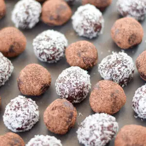 Chocolate rum balls on a pan, some are rolled in coconut and the others in cocoa - square