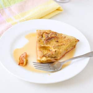 A plate with the pancake with a bite taken out of it - square