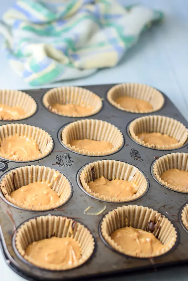 Peanut butter on top of the chocolate in the muffin pan