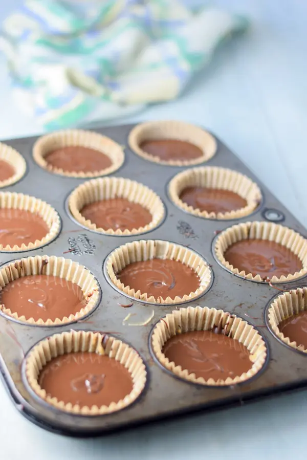 Spooned melted chocolate added to the muffin tins