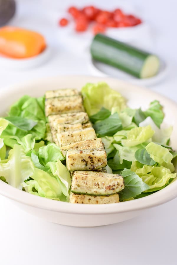 Baked zucchini lined up in the middle of the Boston lettuce