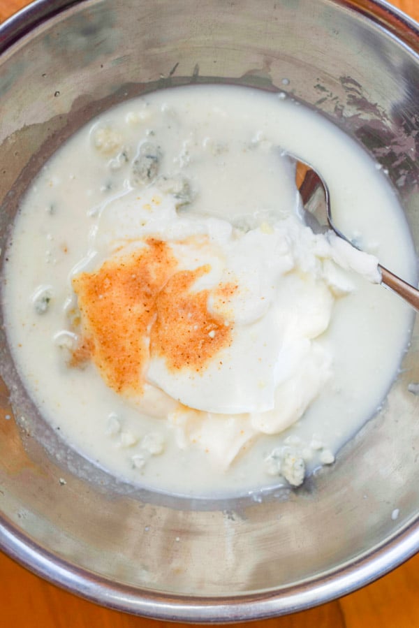 Buttermilk, yogurt, paprika and blue cheese in a metal bowl