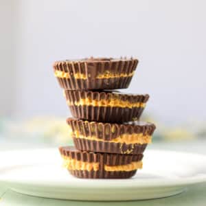 Vertical view of a stack of peanut butter cups on a white plate - square