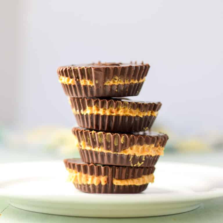 Vertical view of a stack of peanut butter cups on a white plate - square