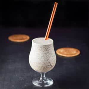 A straw sticking out of a tulip glass filled with the frozen drink - square