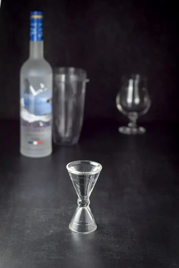 Vodka measured out with the bottle, blender container and glass in the background