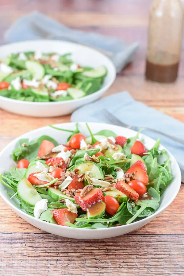 The strawberry arugula salad with balsamic dressing on it