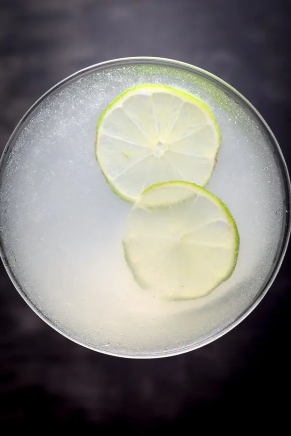 Overhead view of the gimlet with two thin lime wheels floating in it