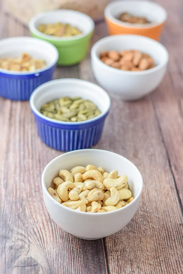 Bowls of cashews, almonds, pistachios, pecans, walnuts and pumpkin seeds