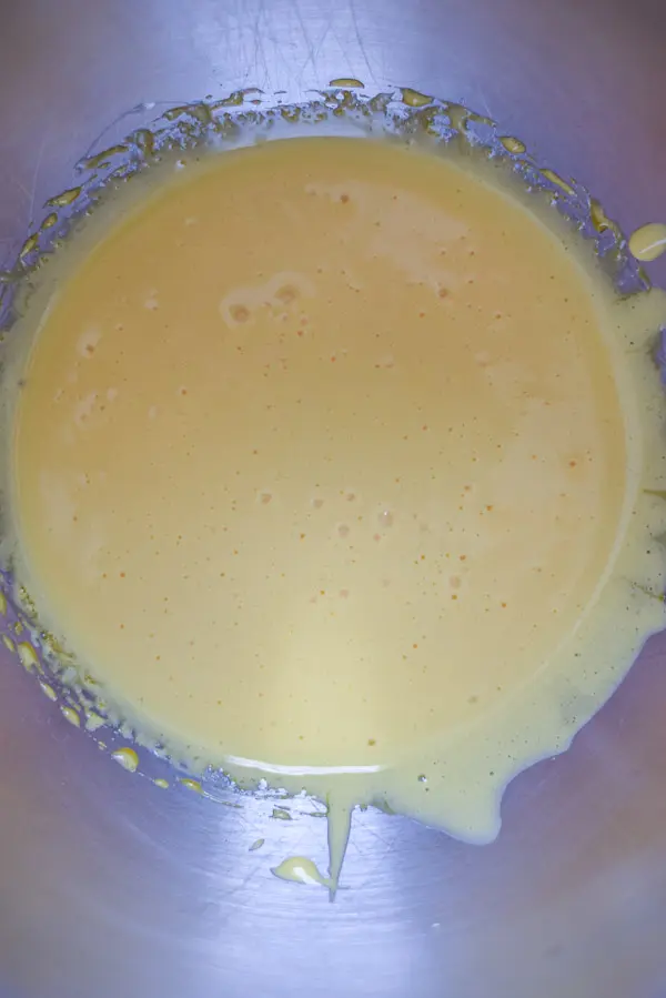 Egg yolks whipped up in a metal mixing bowl