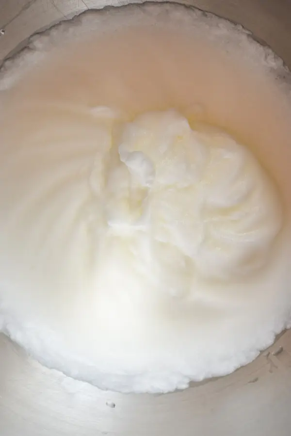 Egg whites whipped up in a metal mixing bowl