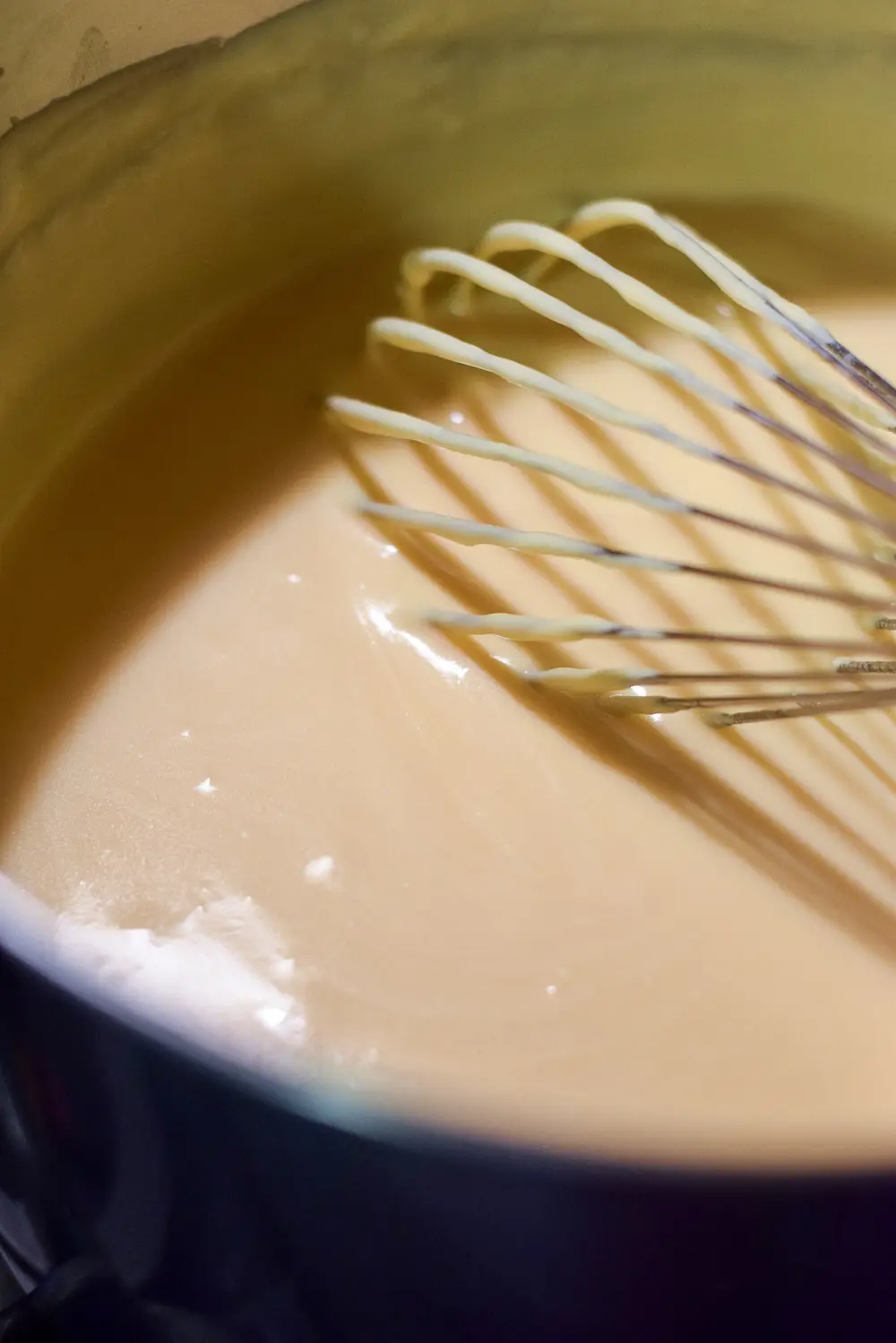 Cheese melted in the roux with a whisk in the pan