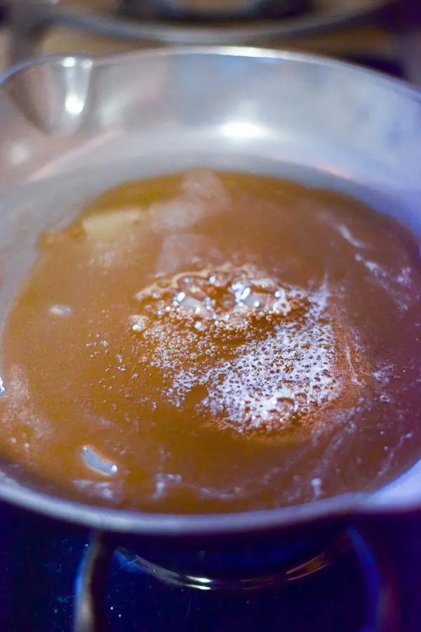 A pan of melted and bubbly sugar on the stove