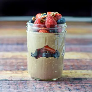 Vertical view of the jar of layered chocolate oat, fruit and nuts - square