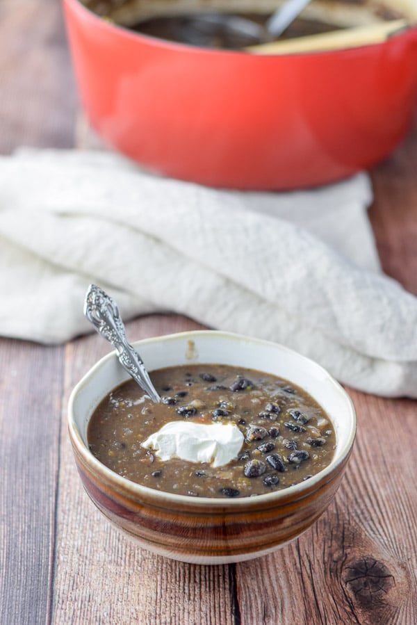 Sour cream ladled in a brown bowl of soup