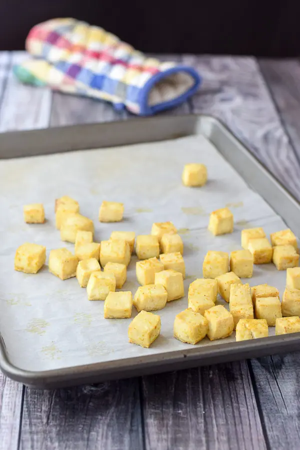 Tofu cubes baked and crispy on a jelly roll pan