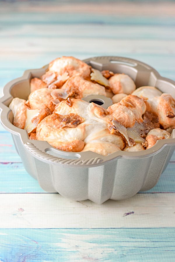 The dough risen in the pan with pecans on it