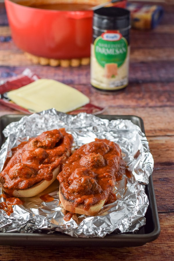 Meatballs and marinara sauce on the bread with cheese and sauce in the background