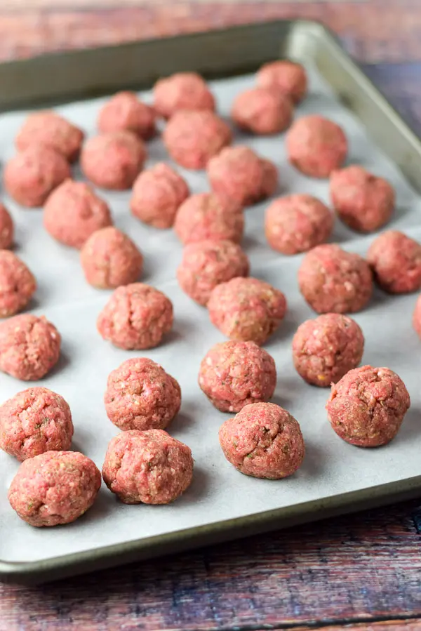 Meatballs formed and on a jelly roll pan