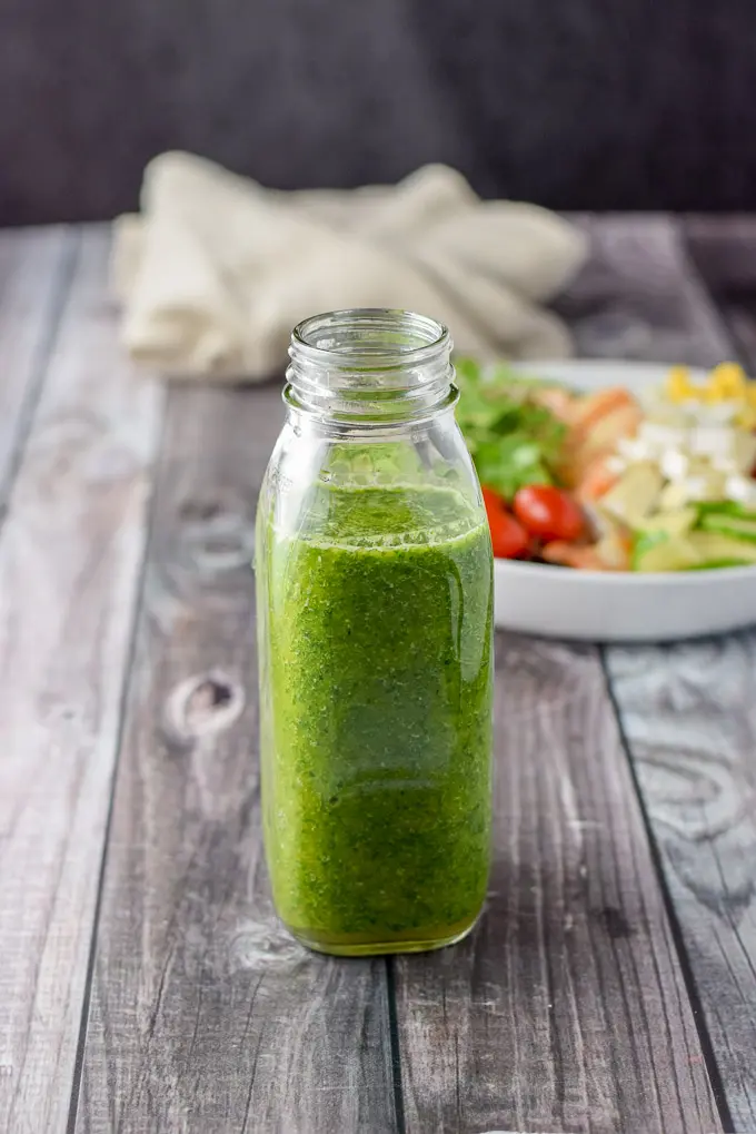 Salad dressing bottle full of the green chimichurri dressing