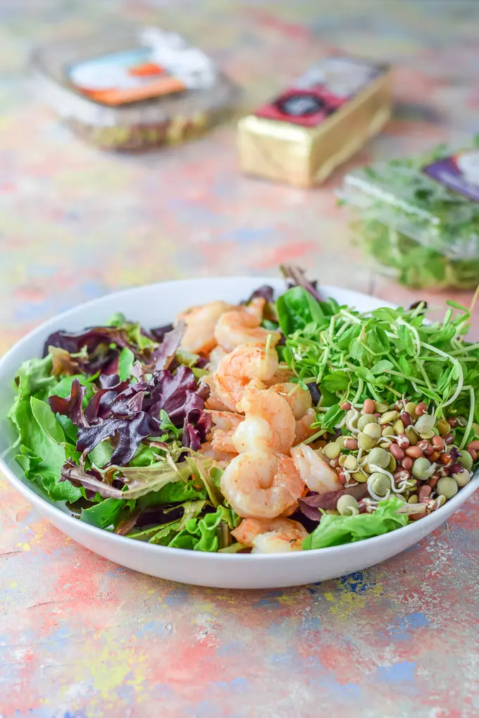 Shrimp in a row, with bean sprouts and pea shoots in the shallow bowl with the lettuce