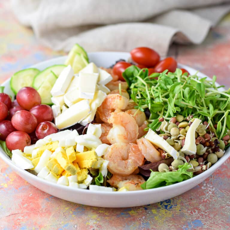Slices of brie cheese and grapes added to the salad - square