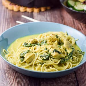 The chicken noodle dish on a shallow blue bowl - square