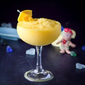 The margarita in a classic glass with mangos on a pick as garnish - square