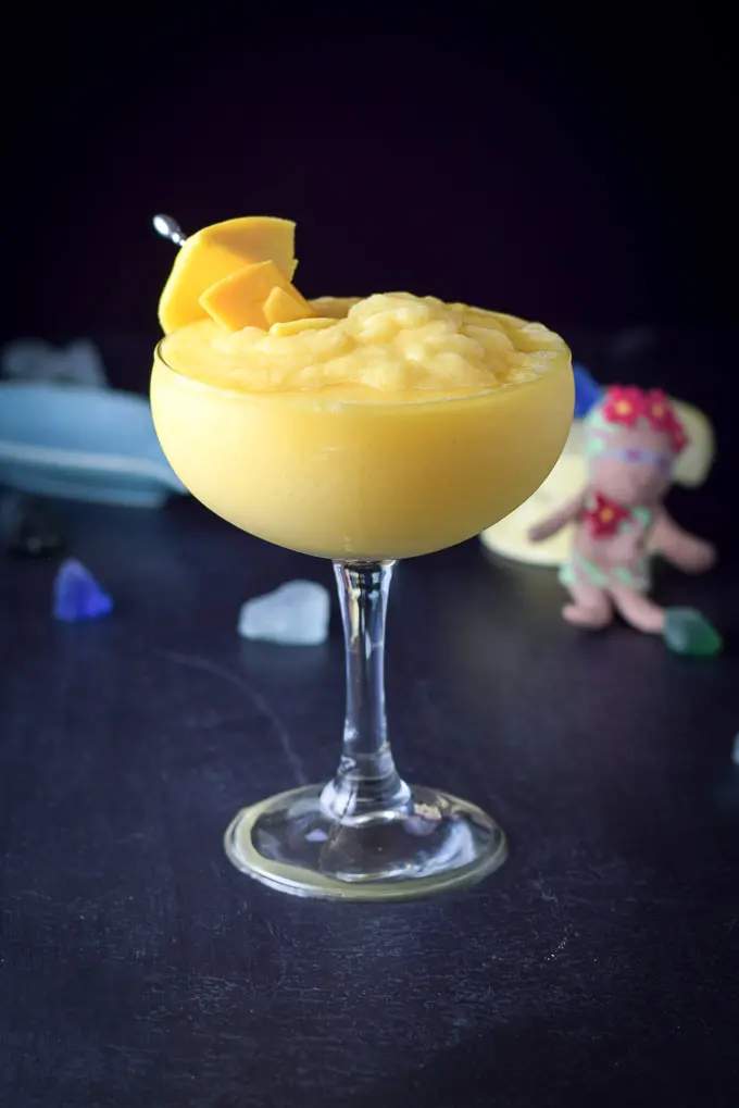 The margarita in a classic glass with mangos on a pick as garnish