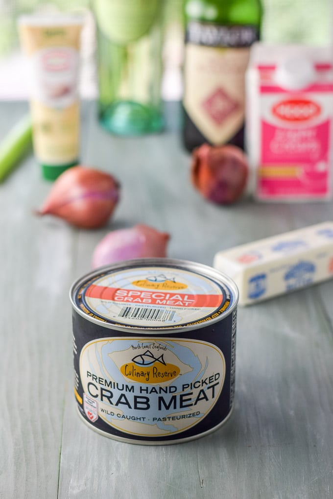 Crab meat, shallots, butter, cream and garlic paste on a grey table