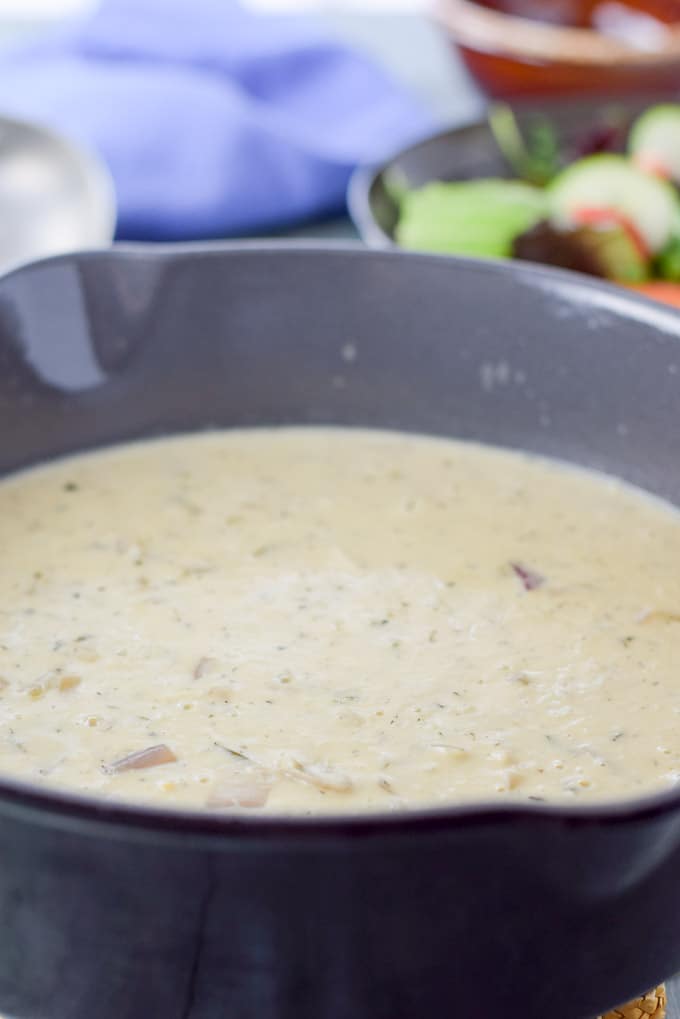 seafood bisque in the grey pan with a salad in the background