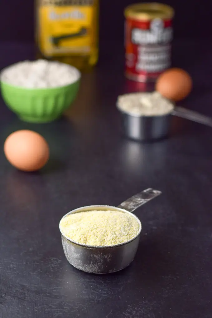 Corn meal, eggs, flour, baking powder and oil on a black table