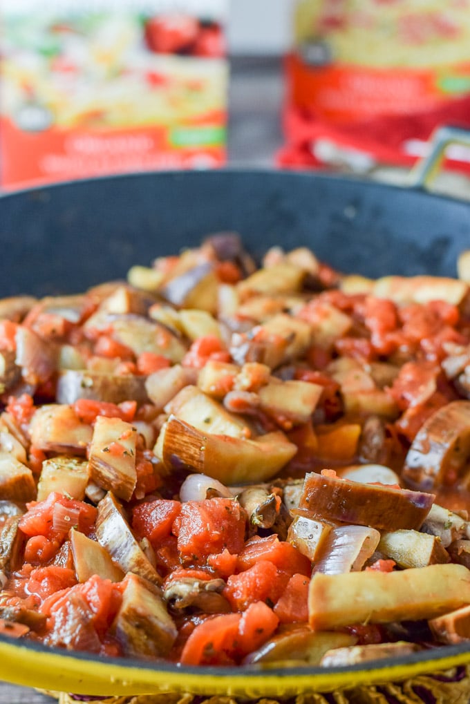 Mushrooms and diced tomatoes added to the shallots and eggplant in the wok