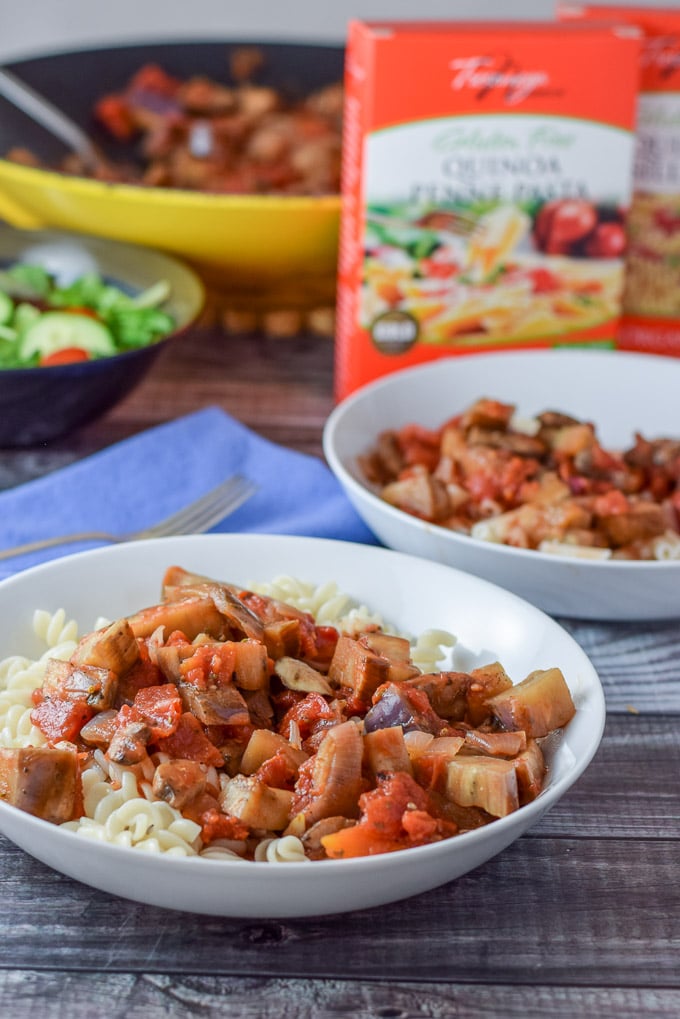 Vegetables on the pasta with boxes of pasta and the wok in the background