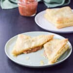 A green plate with a cut piece of baked pastry square with rhubarb in it - square