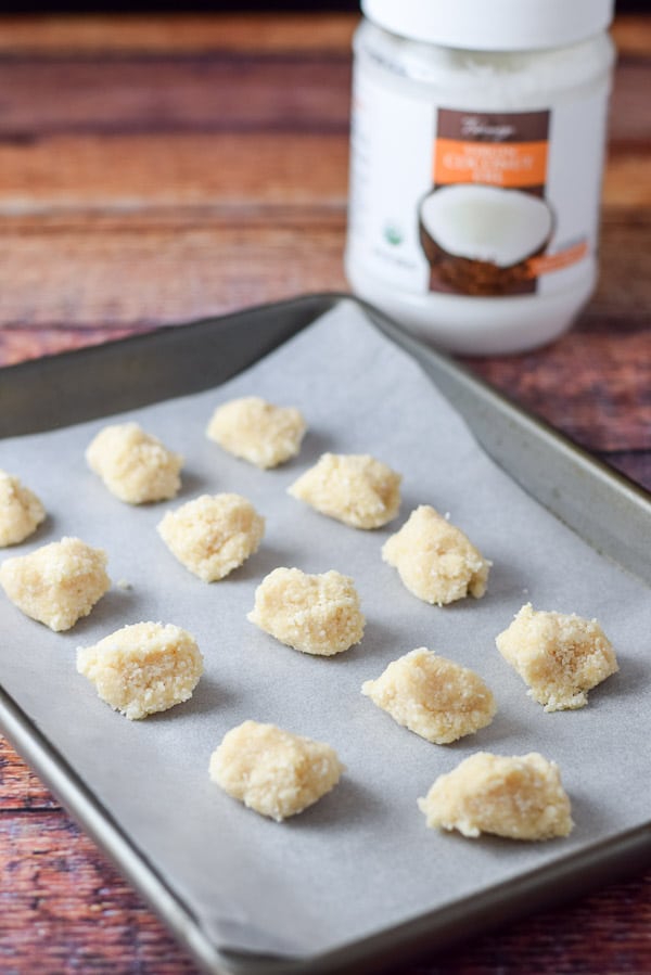 A jelly roll pan containing rolled coconut balls