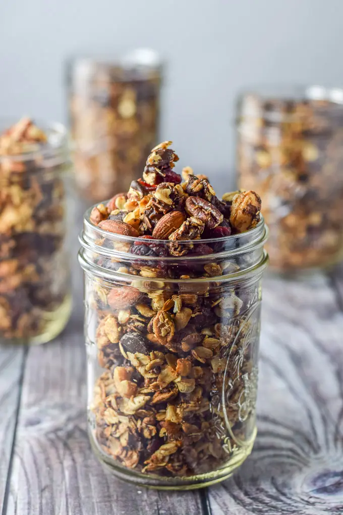 Close up of a jar filled with cranberry granola with the other jars in the background