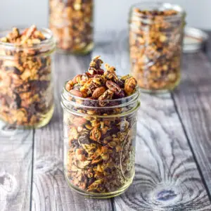 A bunch of jars filled with granola on a grey table - square