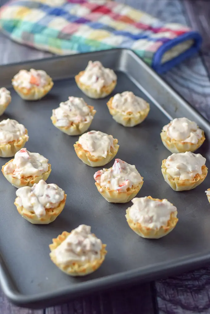Filled phyllo tart shells with the cream cheese lobster mix on a jelly roll pan
