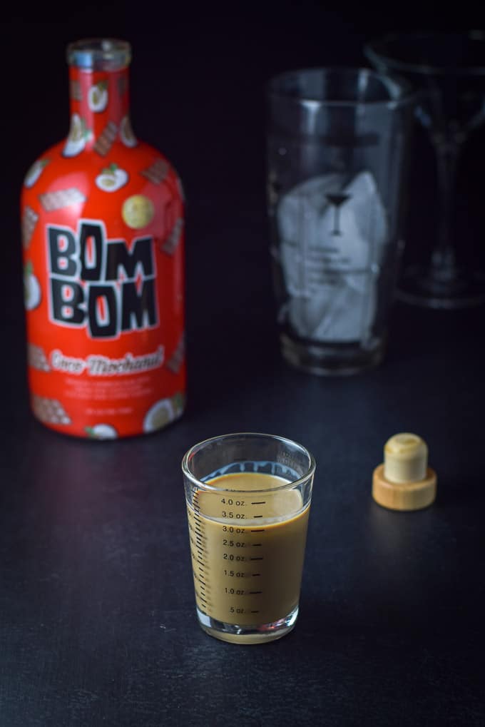 Bom Bom coco mochanut poured out with the bottle, shaker and glass in the background