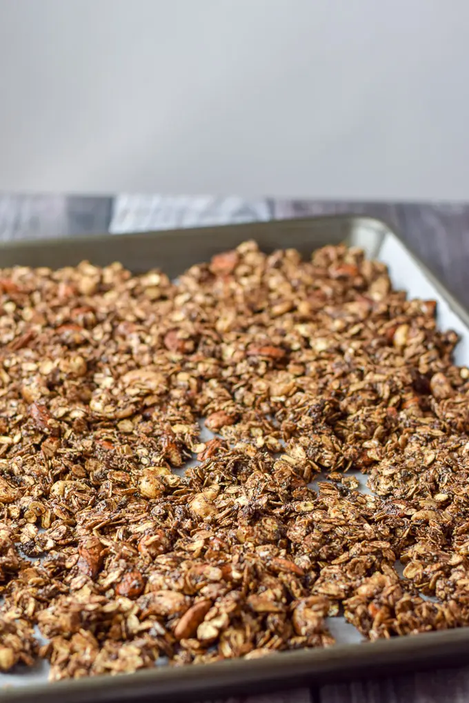 Raw granola on a jelly roll pan ready to be cooked