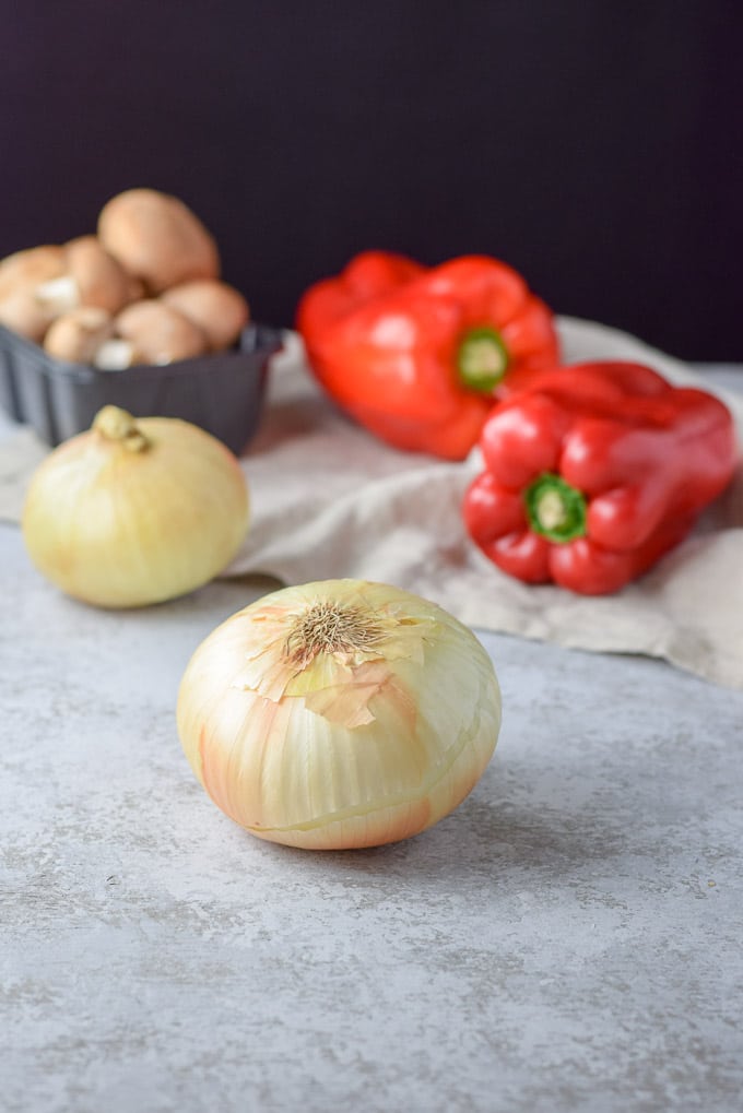 Onions, red peppers and mushrooms on a table