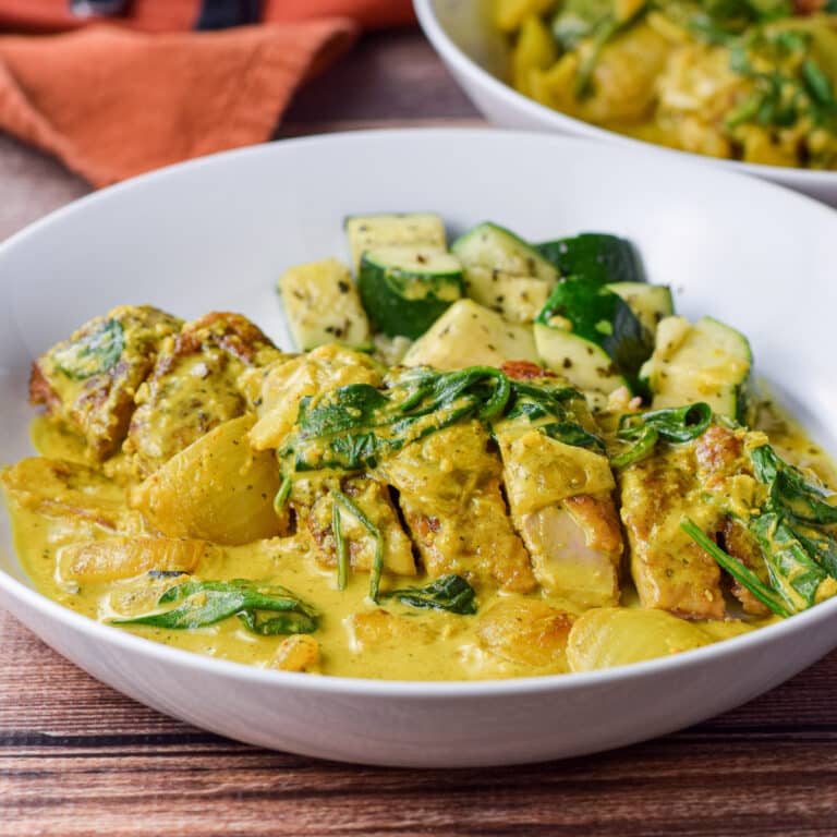 Plated duck curry with zucchini in a white plate - square